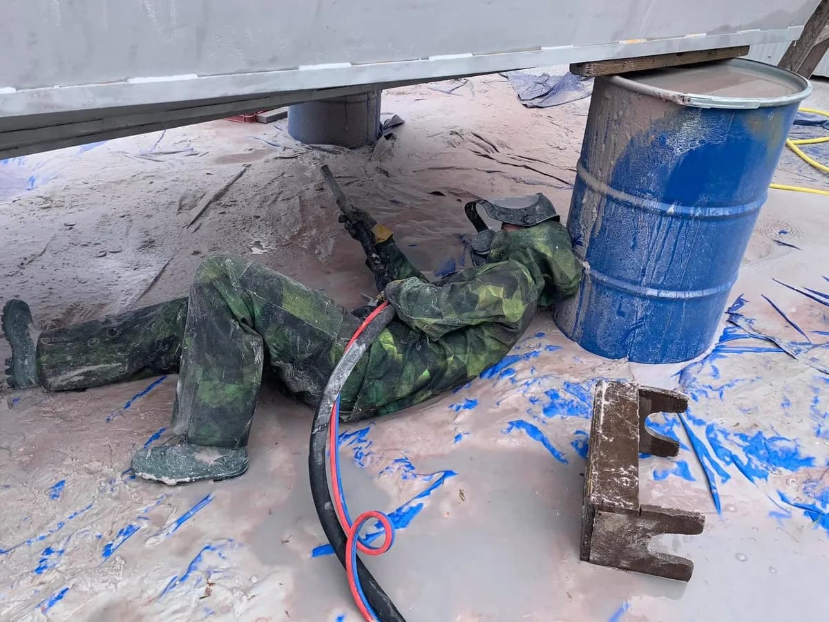 Technicien PRO-FRAME appliquant le traitement anti-corrosion Woolwax sous un véhicule